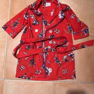 This is a child’s robe. It has a button front, sash, pockets, and a collar.